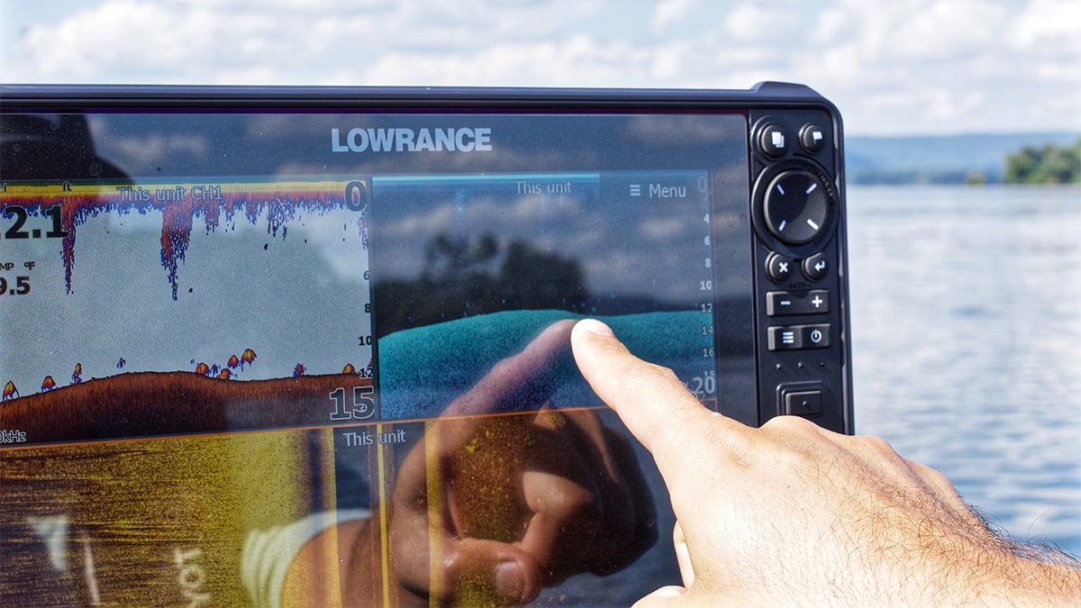 angler points at fish finder while looking for fall bass