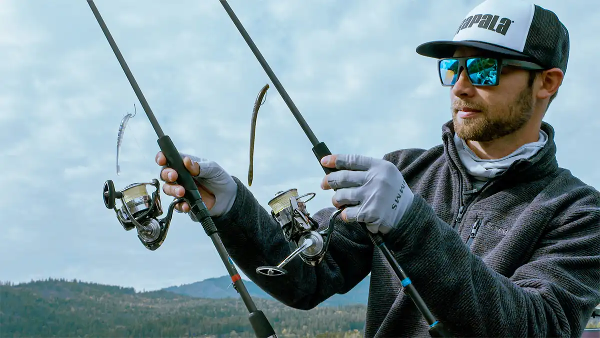 Professional angler holding two rigged spinning gear setups
