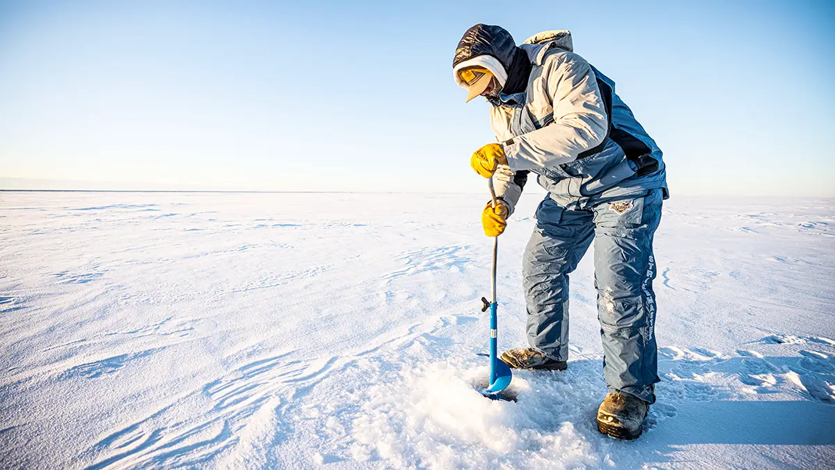 hand ice auger in use