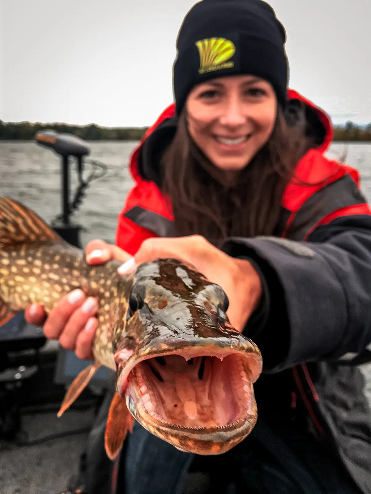 woman holding pike mouth toward camera