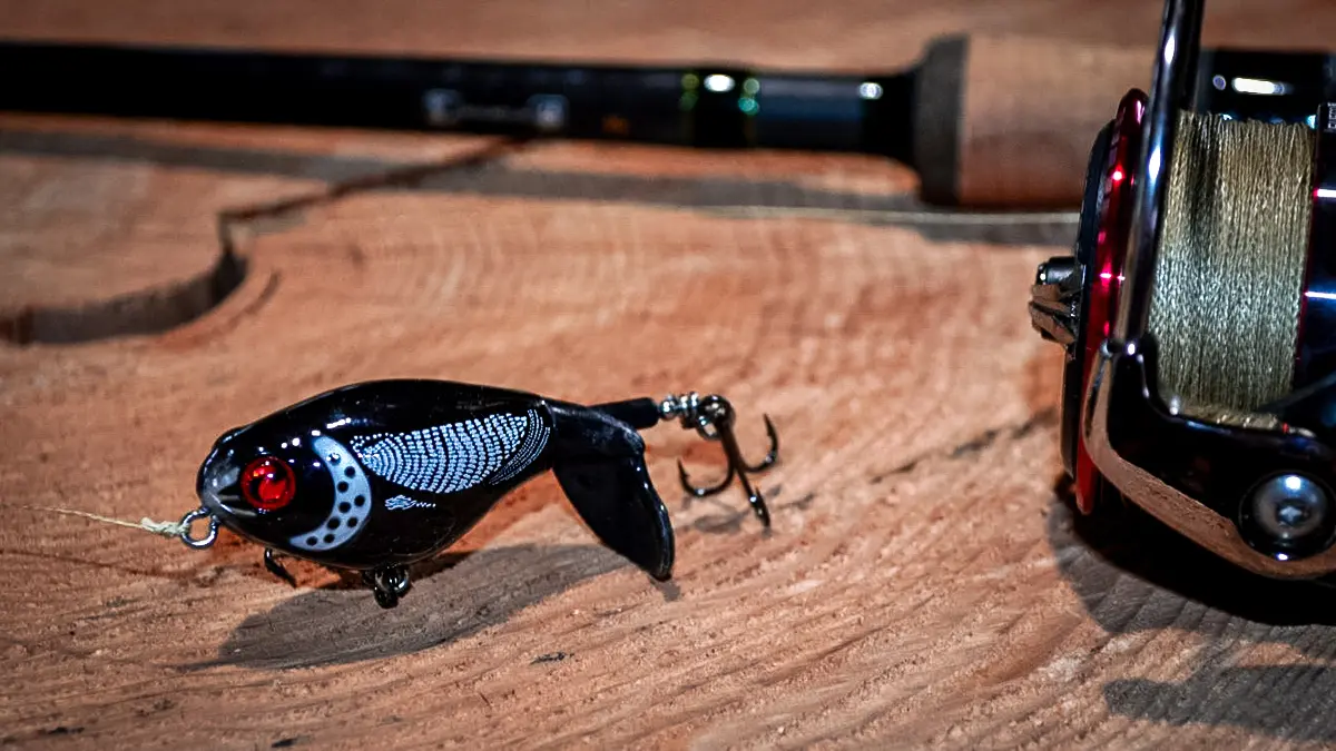 a dark colored Whopper Plopper witha. fishing reel and rod