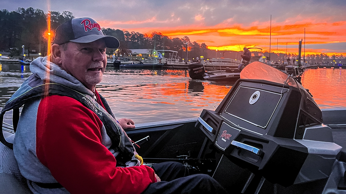 man at boat console with sunset in the background