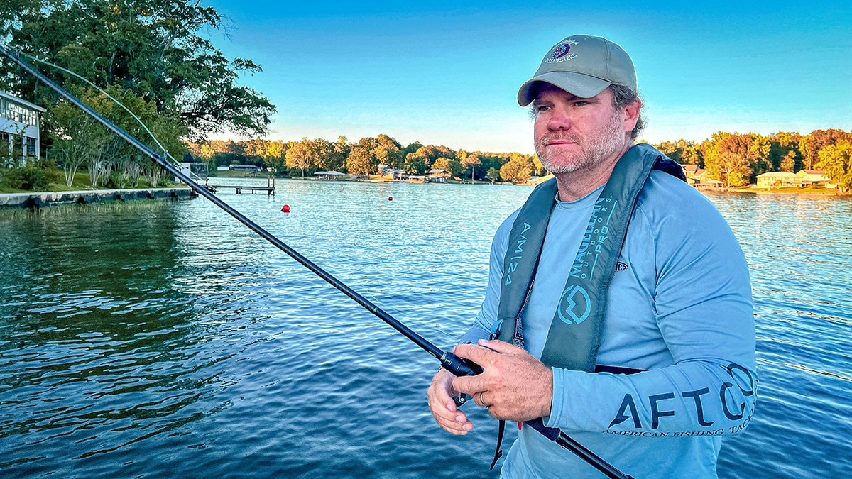 man fishing wearing a personal floatation device PFD