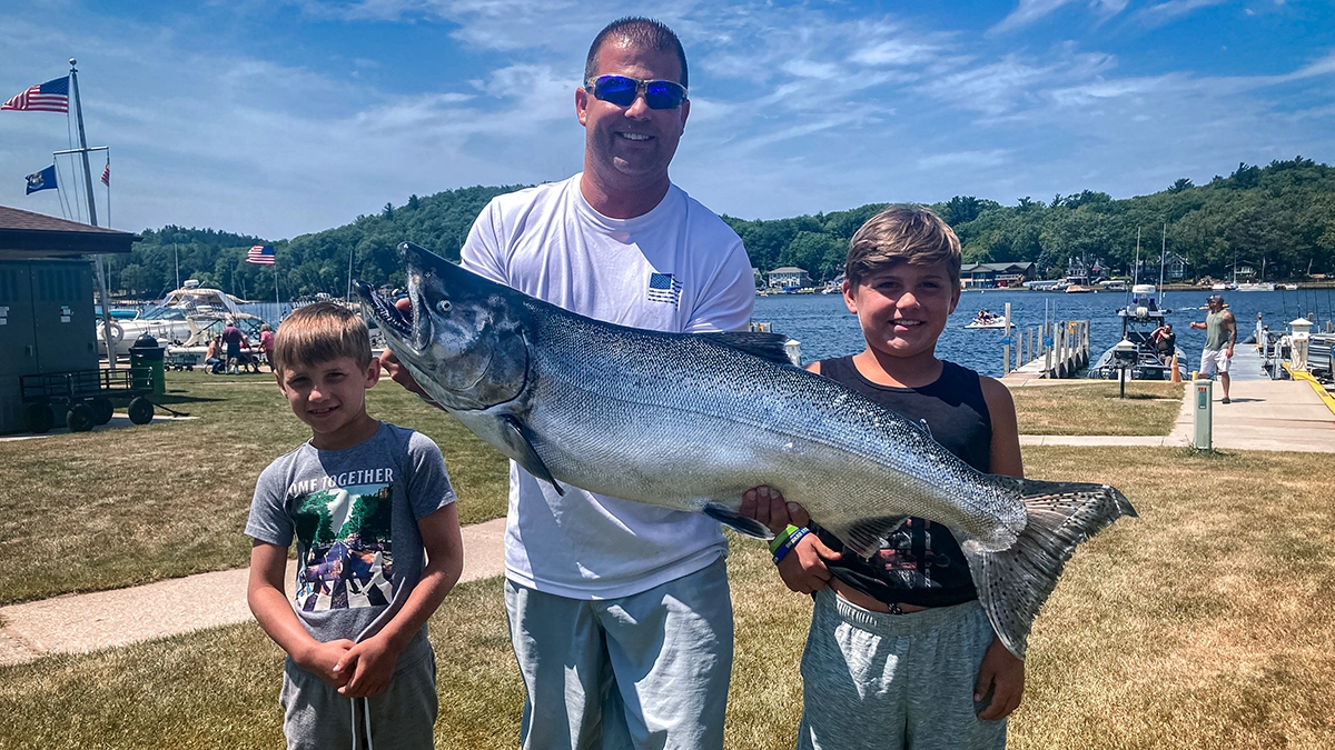 The brothers with their dad and a big salmon