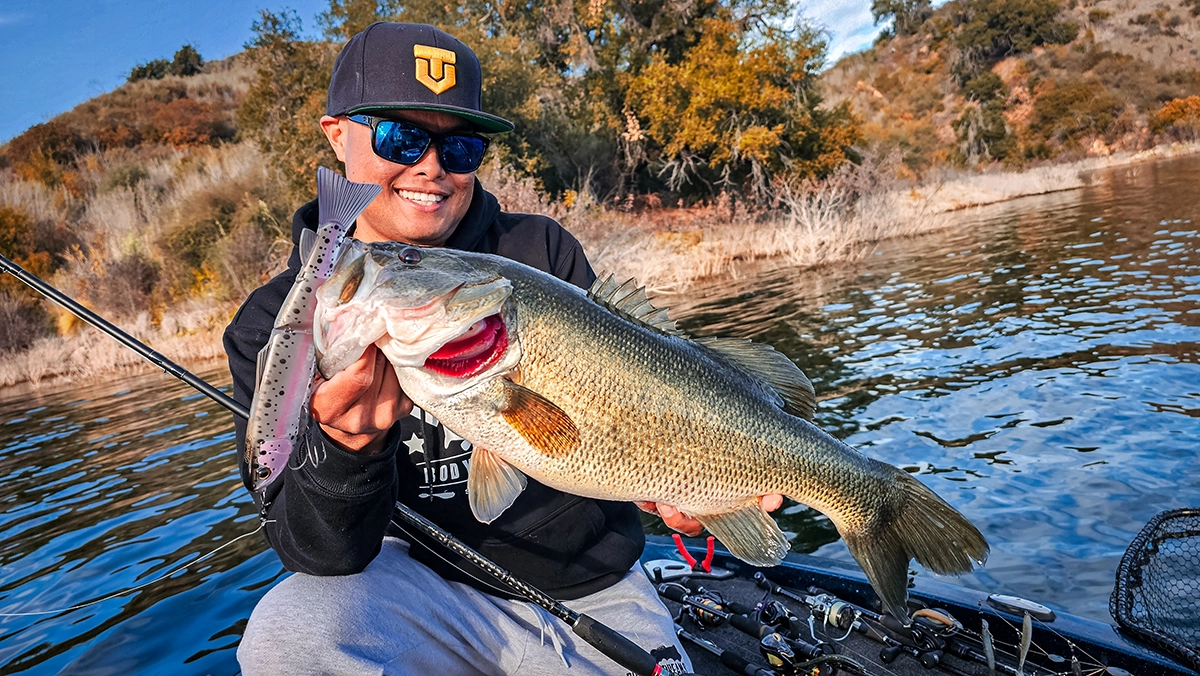 oliver ngy holding a bass hooked on a large glide bait