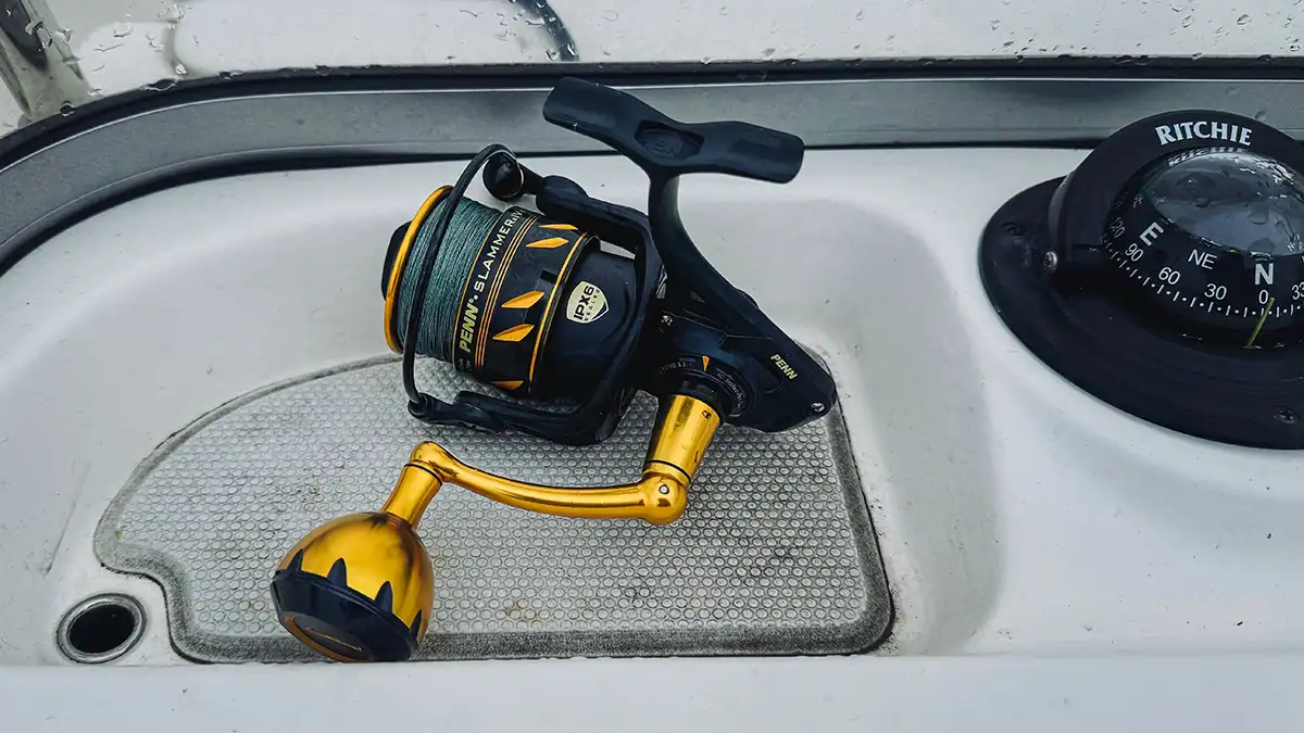 spinning reel on a boat dash next to compass