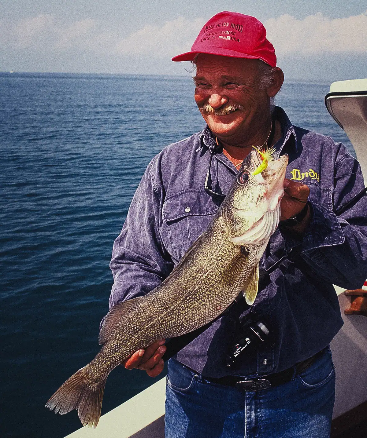 angler holding a lake erie walleye on a boat