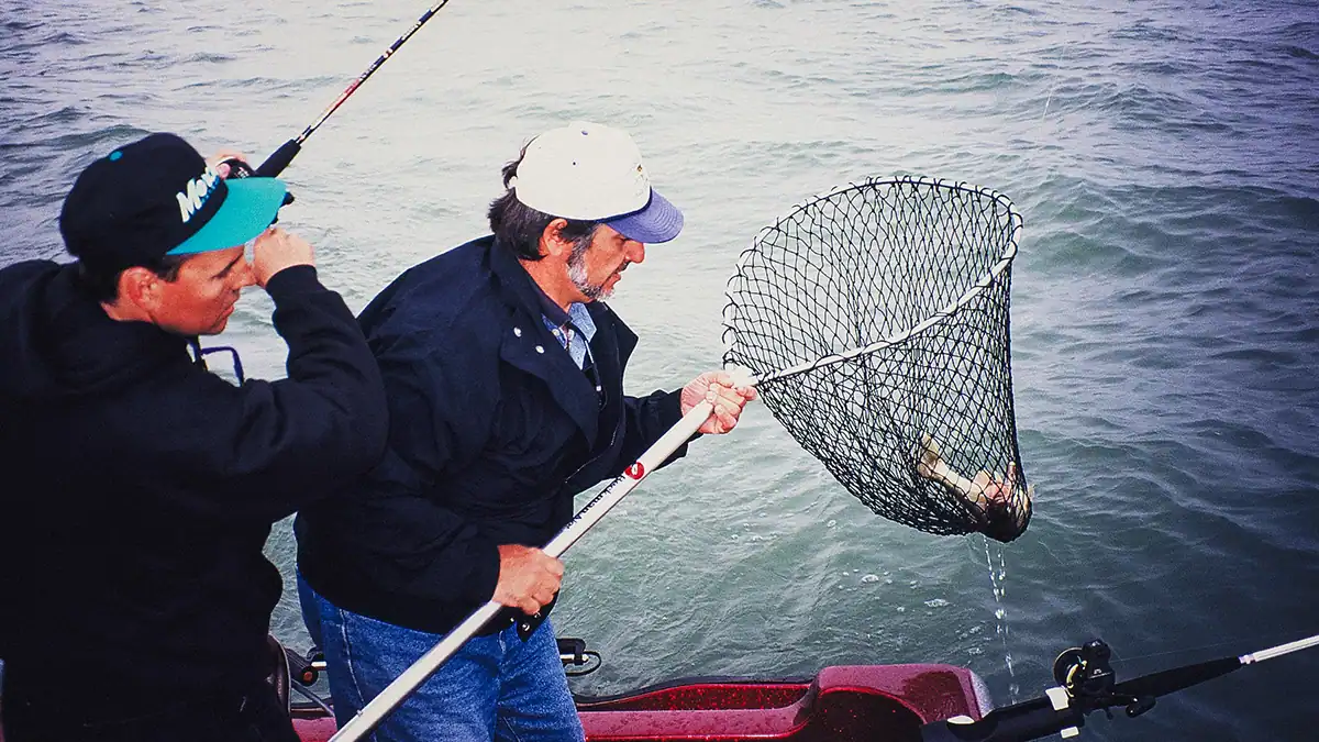 two anglers hauling in a walleye