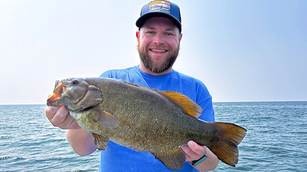 A man holds a largemouth bass.