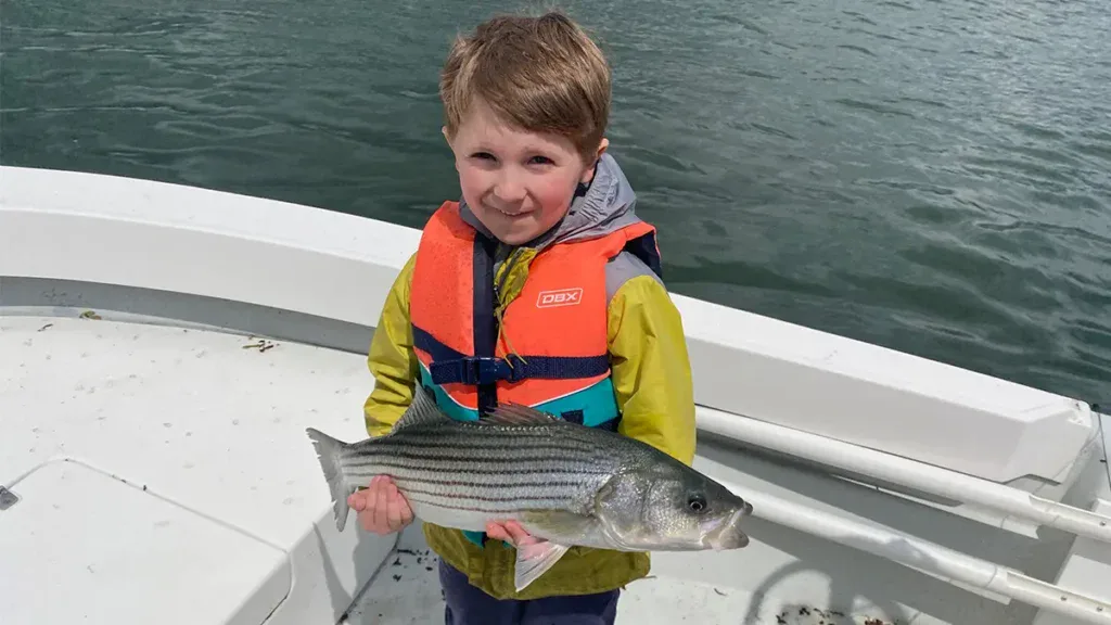 child with striped bass