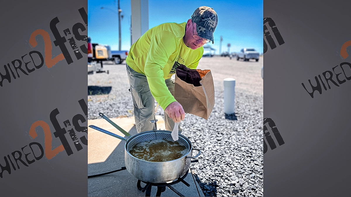 A man places crappie filets into the fryer.