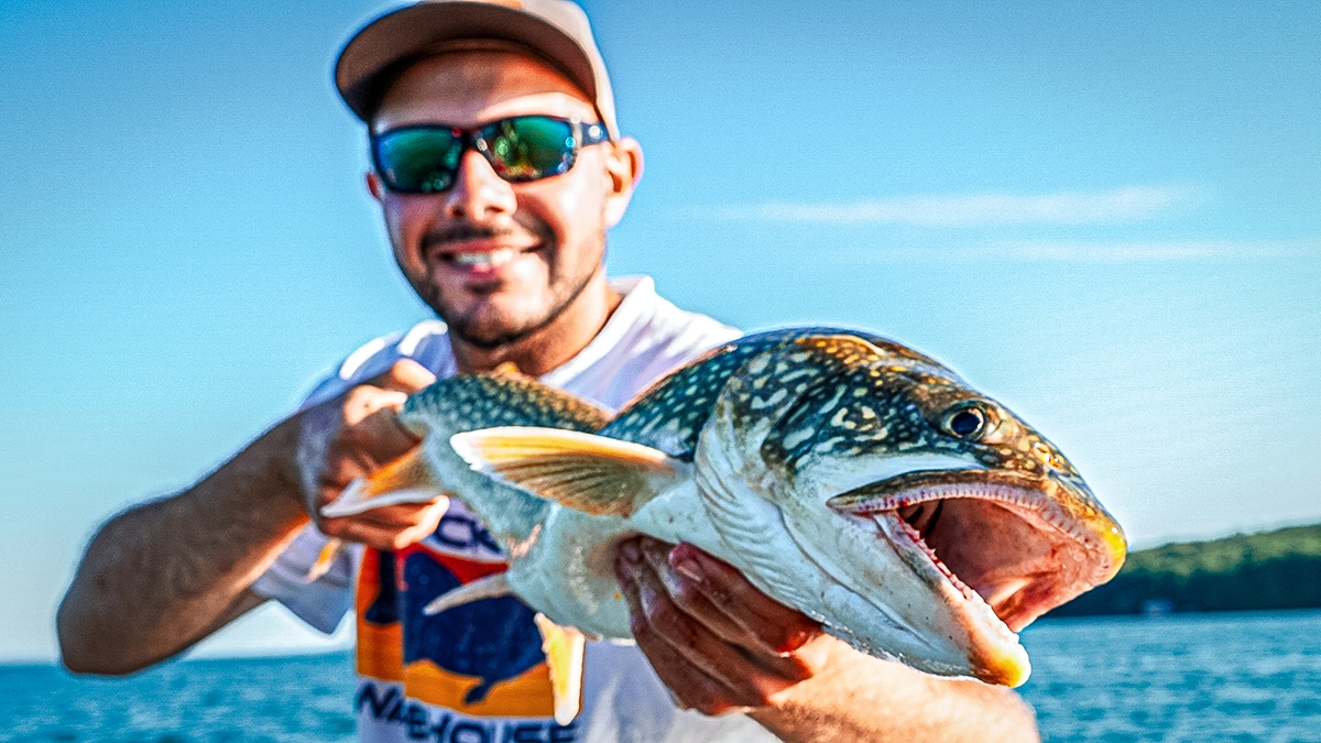 A man on the water holds up a fish