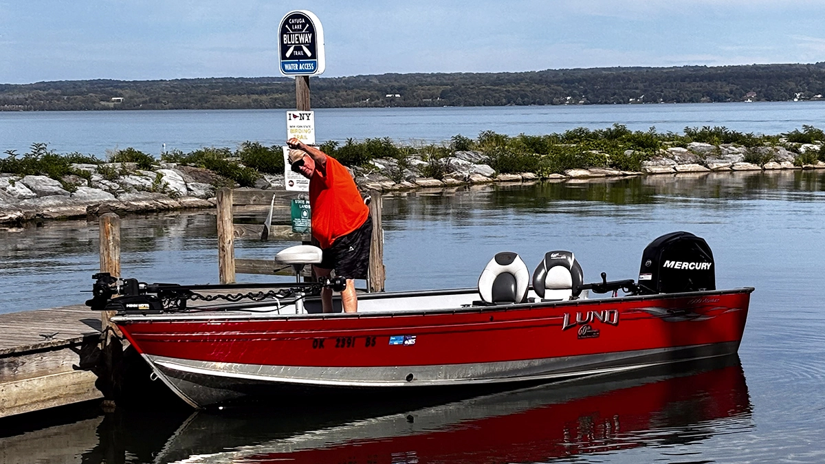 A man raises his fist in a docked red fishing boat