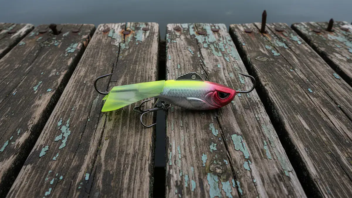 A shiny ACME Tackle Hyper-Rattle on a weathered dock