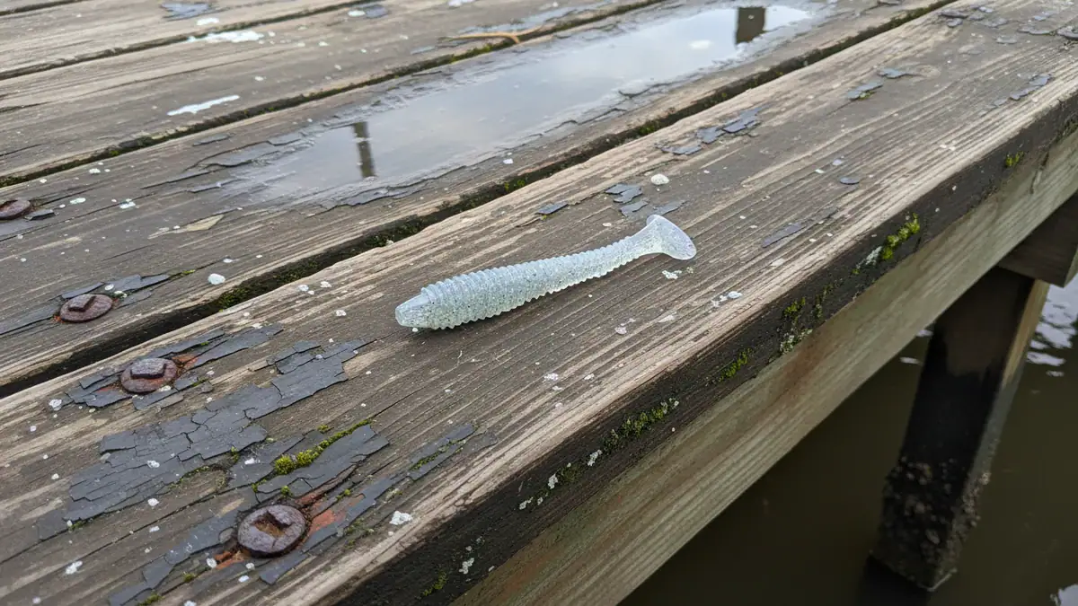 A Strike King Rage Swimmer 24 sits on the wet edge of a dock.