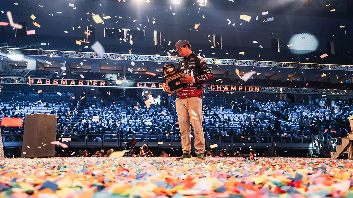 Easton Fothergill holds his trophy on stage after winning 2025's Bassmaster Classic.