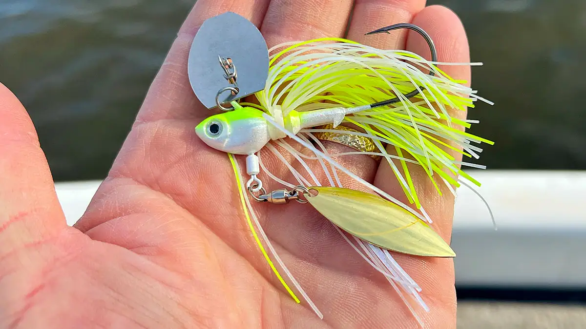 A hand holding the Fish Head Primal Vibe Jig.