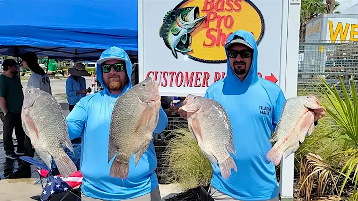 Two anglers hold some invasive-species fish caught during last year's SWFL CISMA Invasive Freshwater Fish Roundup.