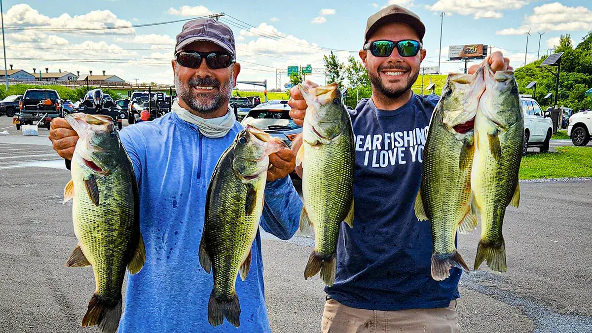 Two men show off the five fish they caught between them.