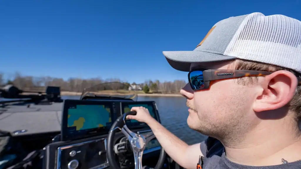 Angler with Island Optics glasses driving bass boat