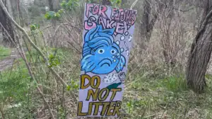 Hand-painted sign encouraging people not to litter for the sake of the fish.