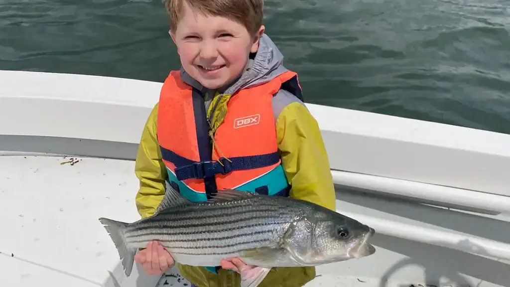 small boy with striped bass