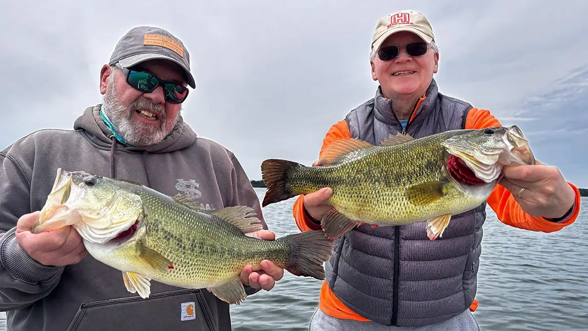 Two men show off their bass.