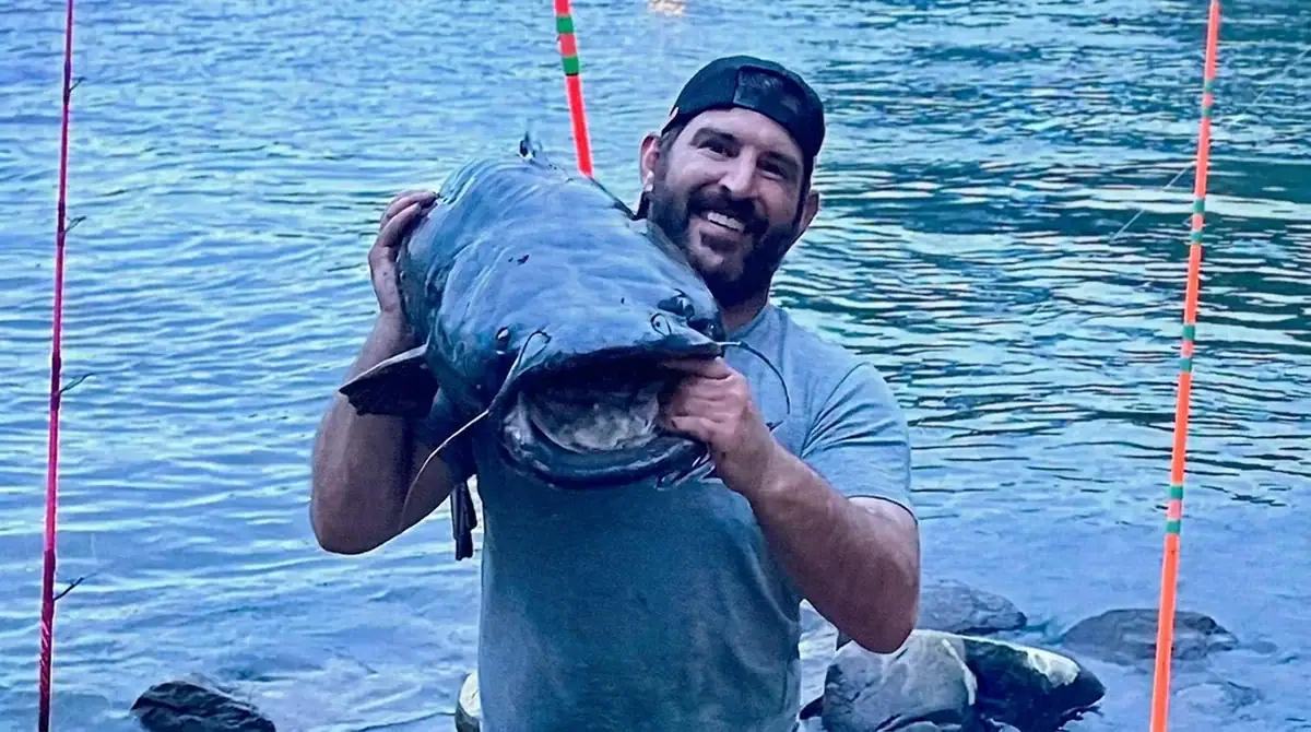 Andrew Karsten shows off the 48.1-pound flathead catfish he recently caught in Michigan’s St. Joseph River before releasing it back into the water.