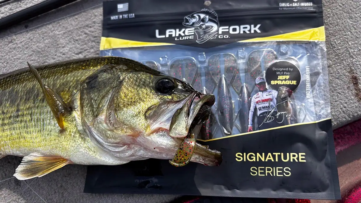 A fish and a package of Lake Fork Pro Craw lures, one of which is in the fish's mouth.